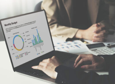 Closeup business developer team discussing,meeting,working with computer laptop and tablet while sitting together at wooden working desk over orderly living room as background..
