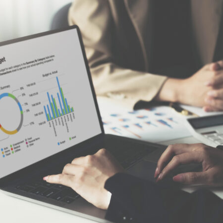Closeup business developer team discussing,meeting,working with computer laptop and tablet while sitting together at wooden working desk over orderly living room as background..